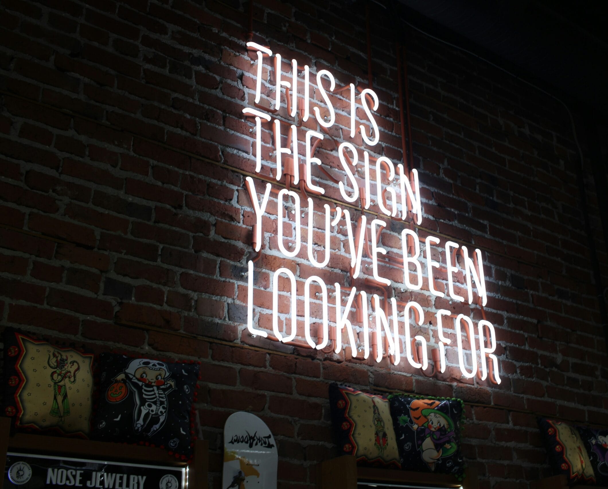 Neon Sign dark brick background "This is the sign you've been looking for"