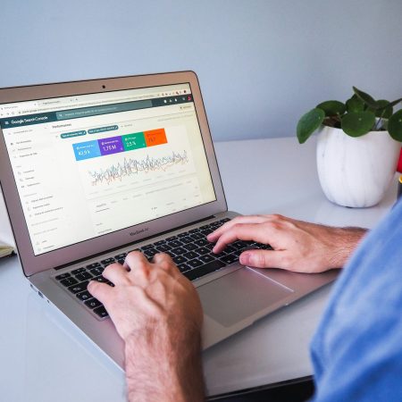 Web design and seo results person working on a laptop with a graph on the screen